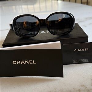 CHANEL Elegant Black Sunglasses with White accents.